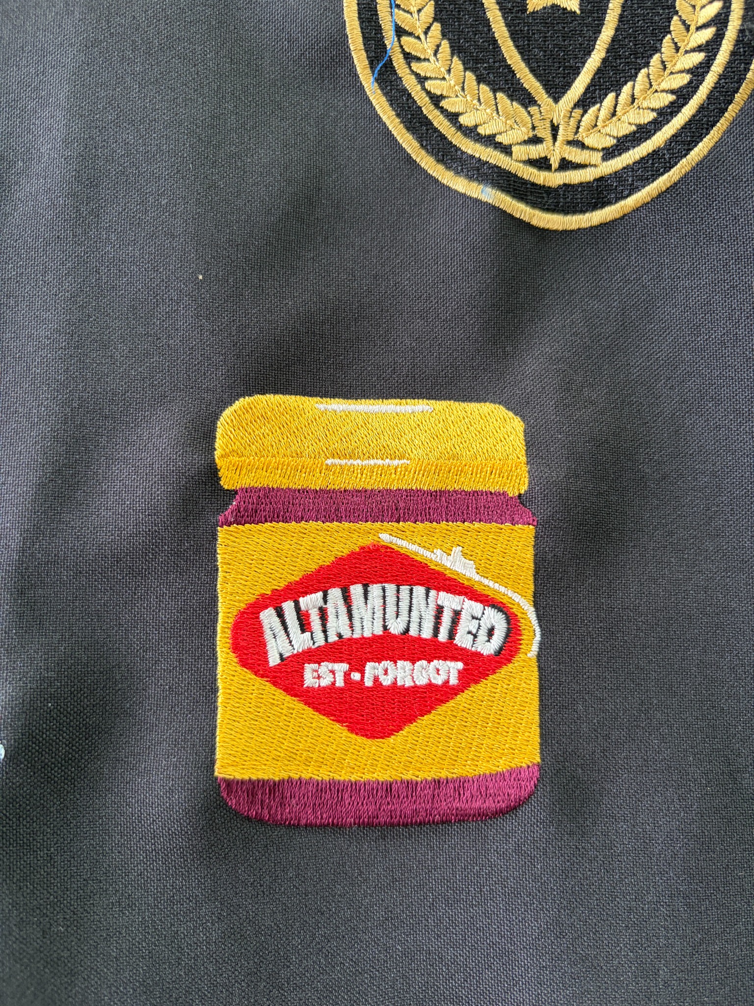 Colourful Altered snack packet embroidery on dark fabric